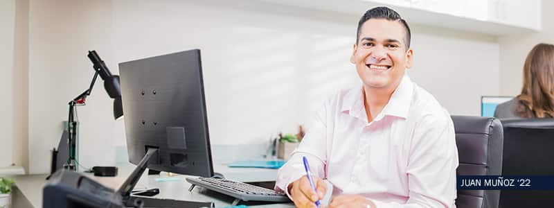 SNHU Alumni Juan Munoz in front of computer