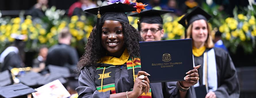 SNHU graduate showing off her diploma during the 2024 SNHU Commencement Weekend