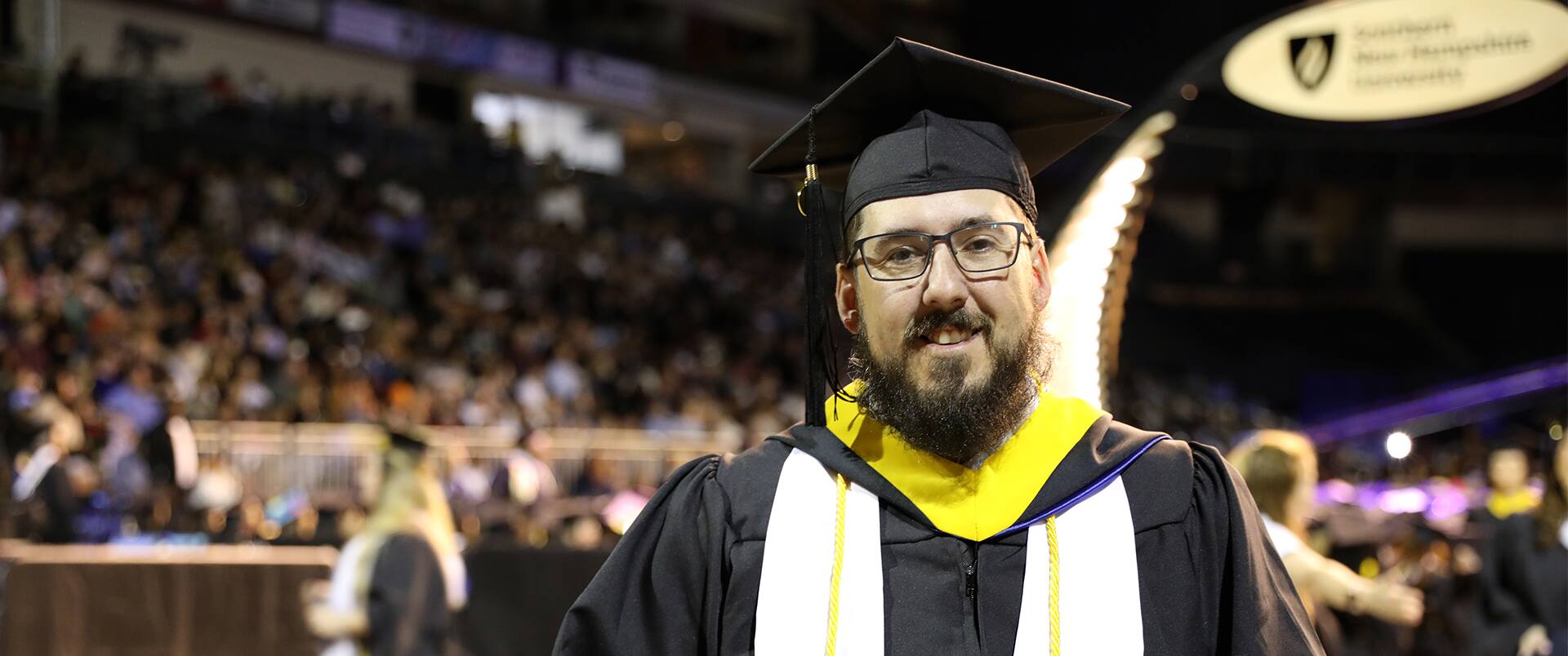 Michael Richards, clad in cap and gown at the 2023 SNHU commencement ceremony after earning his software engineering degree online.