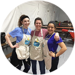 Hannah Lewis, Elaina Hill and Arielys Liriano wearing aprons in a Washington D.C. soup kitchen where they volunteered during spring break.