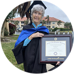 Florida resident and SNHU graduate Joan Donovan wearing her cap and gown and holding her framed SNHU diploma.