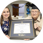 Florida resident and SNHU graduate John Draper wearing his graduation cap and holding his framed diploma alongside SNHU academic advisor Courtney Hannon.