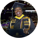 Nevada resident and SNHU graduate Robyn Roberts in her cap and gown and holding her diploma at the SNHU commencement.