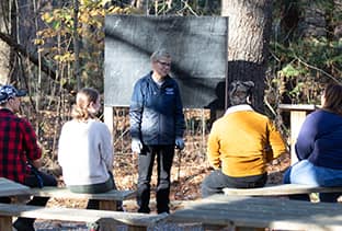SNHU Assistant Director of Sustainability Programs Pamela Backvagni speaking to a small group of students in SNHU’s outdoor classroom